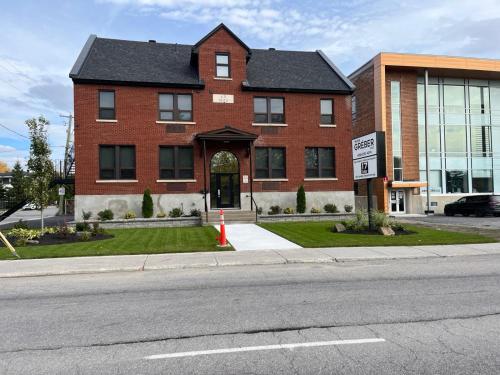 a red brick building with a black roof at Cozy Maison Apt #3 in Gatineau