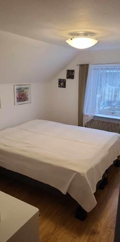 1 cama blanca grande en un dormitorio con ventana en Villa Svalan, en Hällefors