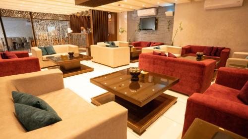 a living room with couches and tables and a television at My Hotel by Trend in Aqaba