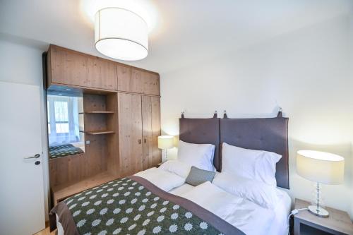 a bedroom with a large bed with a wooden headboard at Apartmenthaus Pastner am Teich in Übelbach