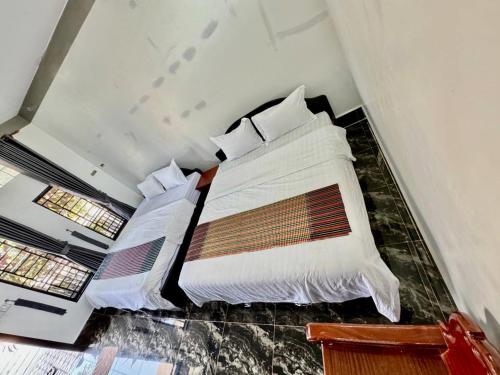Asia Ready Travel & Tours Siem Reap في سيام ريب: غرفة نوم بسرير كبير عليها شراشف ووسائد بيضاء