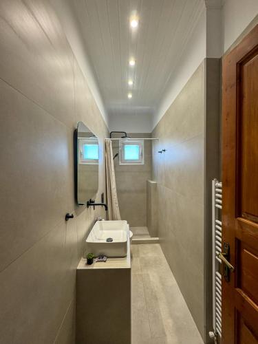 łazienka z umywalką i lustrem w obiekcie Villa Anel w mieście Spetses