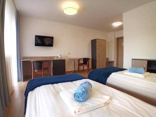 a hotel room with two beds and a desk at Ośrodek Wypoczynkowo-Leczniczy OPOLE w Dźwirzynie in Dźwirzyno