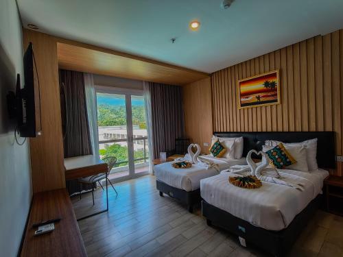a hotel room with two beds and a balcony at Raja Hotel Kuta Mandalika Resort & Convention in Kuta Lombok