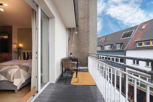 a bedroom with a balcony with a bed and a desk at Modern Apartment with City-View and car park in Essen