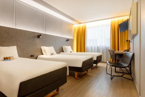 a hotel room with two beds and a desk at Metropol Hotel in Tallinn