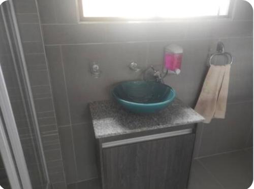 a bathroom with a blue bowl sink on a counter at Brand new crane Apartments no 9 in Lenasia