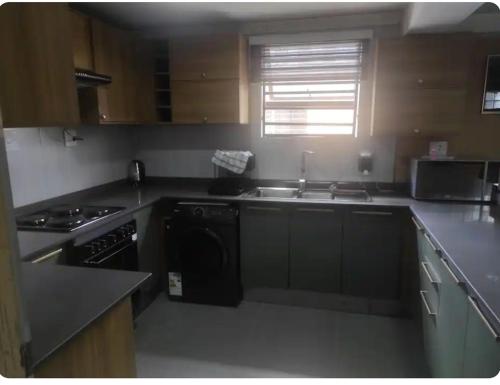 a kitchen with a sink and a stove top oven at Brand new crane Apartments no 9 in Lenasia