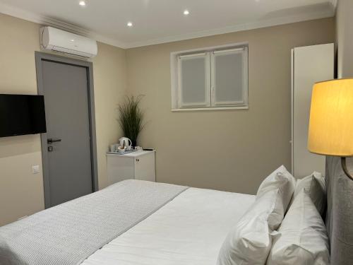 Schlafzimmer mit einem großen weißen Bett und einem Fenster in der Unterkunft Vila Niki in Sovata