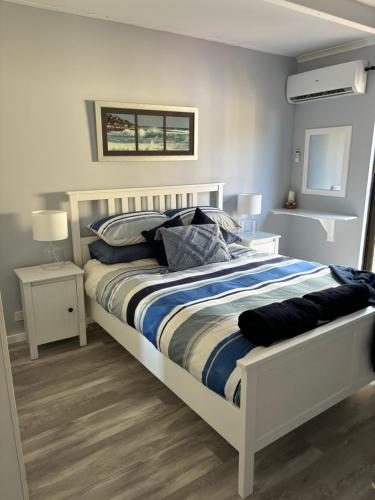 um quarto com uma cama branca e duas mesas de cabeceira em Kalbarri Sunset Villa em Kalbarri