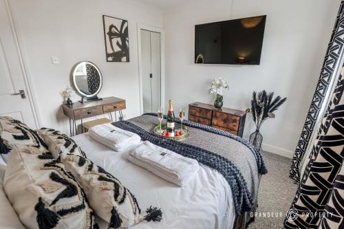 a bedroom with a bed with a tv on the wall at The Catalina Breeze by Grandeur Property in Poole