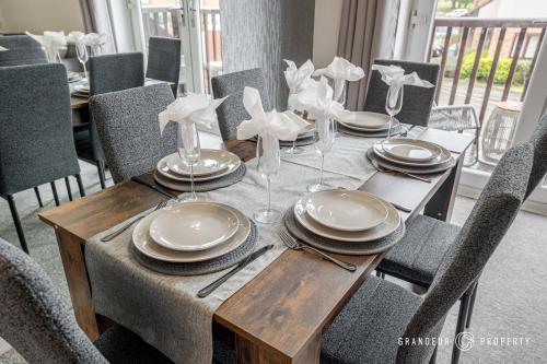 a dining room table with plates and glasses on it at The Catalina Breeze by Grandeur Property in Poole