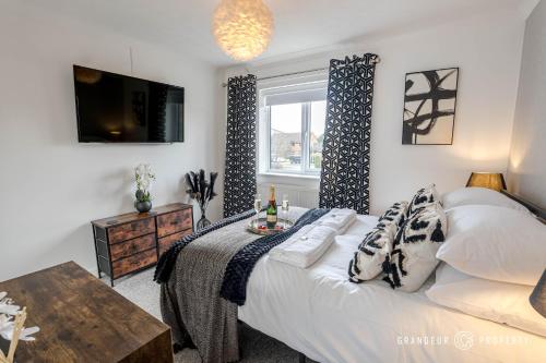 a bedroom with a bed and a tv and a window at The Catalina Breeze by Grandeur Property in Poole