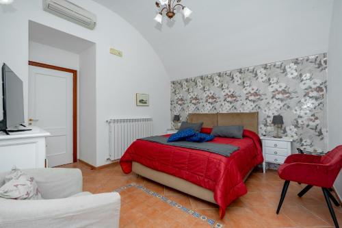 1 dormitorio con 1 cama con colcha roja en Ferriere Apartment, en Scala