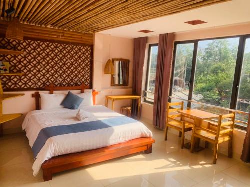 Un dormitorio con una cama grande y una mesa y sillas. en Sapa indigo inn, en Sa Pa