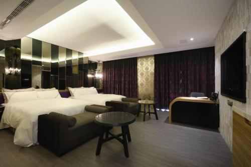 a hotel room with a bed and a couch at U-Her Hotel in Taichung