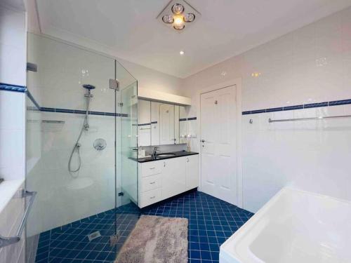 a bathroom with a shower and a sink at Maroubra Gem Close to Everything Sleep 16 in Sydney