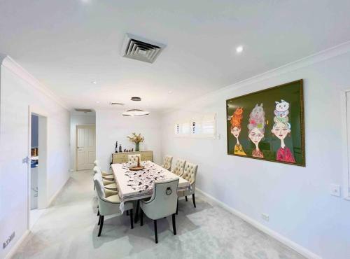a white dining room with a table and chairs at Maroubra Gem Close to Everything Sleep 16 in Sydney