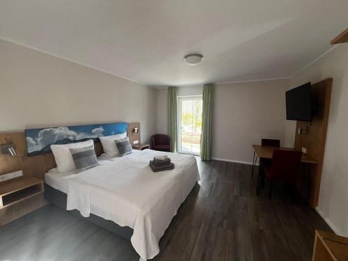 Schlafzimmer mit einem großen weißen Bett und einem Schreibtisch in der Unterkunft Apartments Urlaub im Chiemgau in Aschau im Chiemgau