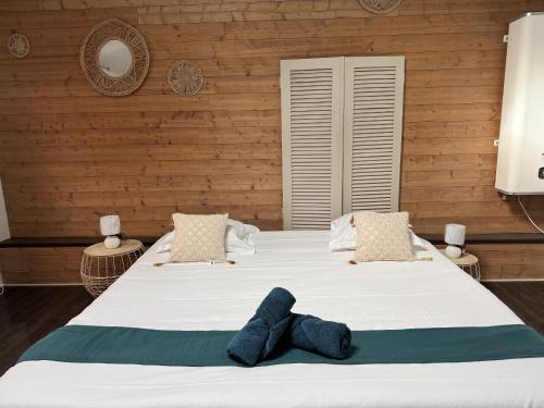 - une chambre avec un grand lit blanc et des murs en bois dans l'établissement L Agreable Suite Circuit Reve au Mans, à Écommoy