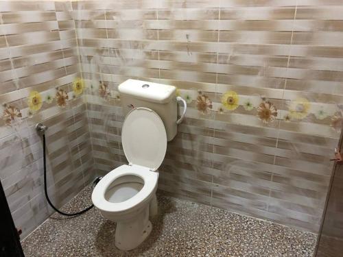 a bathroom with a toilet with flowers on the wall at HOMESTAY PERLIS MURAH in Arau