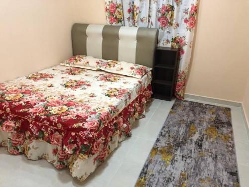 1 Schlafzimmer mit einem Bett mit Blumendecke in der Unterkunft HOMESTAY PERLIS MURAH in Arau