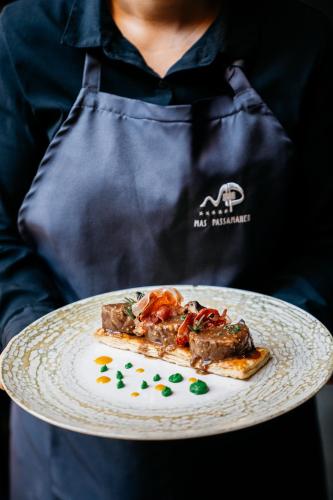 a person holding a plate with a piece of food at Hotel Boutique Mas Passamaner in La Selva del Camp