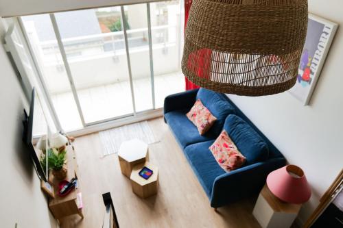 een woonkamer met een blauwe bank bij Appartement rénové avec goût et idéalement situé à deux pas du remblai in Les Sables-dʼOlonne