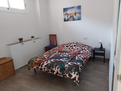 Un dormitorio con una cama con una manta. en Casa di Maritz 10b, en Palafolls