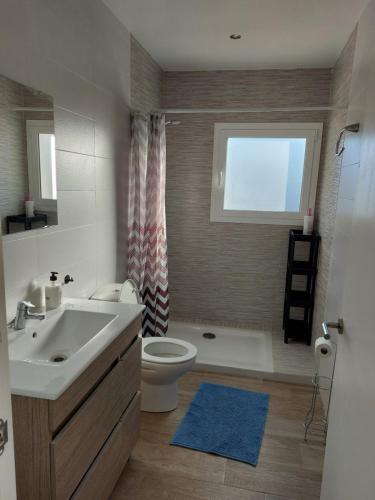 uma casa de banho com um lavatório, um WC e uma janela. em Casa di Maritz 10b em Palafolls