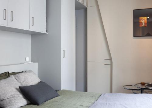 - une chambre avec un lit et des armoires blanches dans l'établissement Tiny House Paris Nord, à Paris