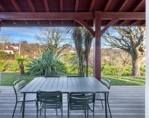 une table et des chaises en bois sur une terrasse dans l'établissement La Senpere - Maison à 20min de Saint Jean de Luz, à Saint-Pée-sur-Nivelle