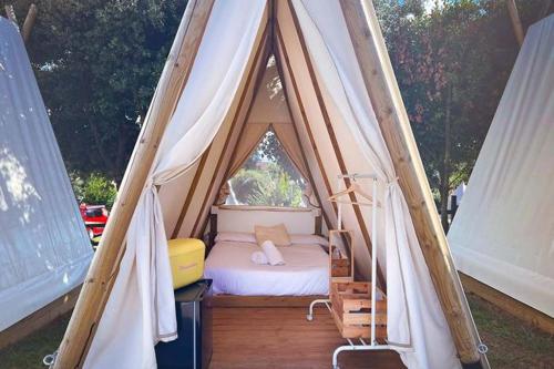 a tent with a bed in the middle of it at Kampaoh Somo Playa in Somo