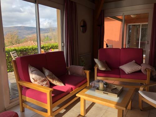 a living room with two chairs and a table at l'Espinet Vacances in Quillan