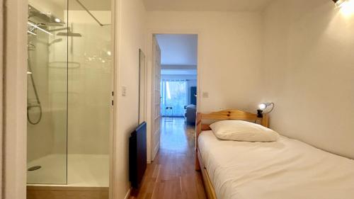 een slaapkamer met een bed en een glazen douche bij Les Tamaris in Le Crotoy