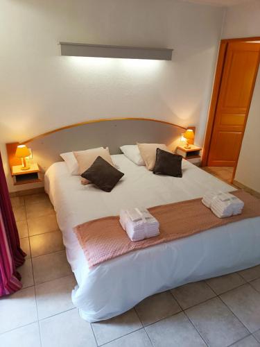 a large white bed with two pillows on it at l'Espinet Vacances in Quillan