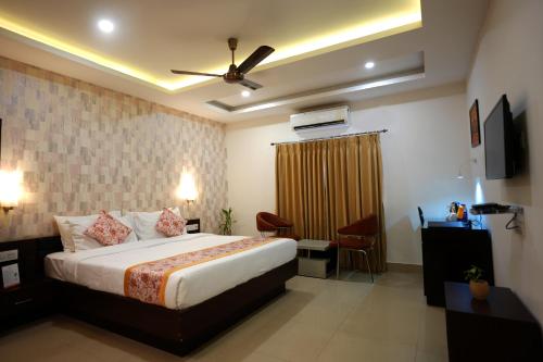 Habitación de hotel con cama y ventilador de techo. en Voyage Comfort Primer Inn en Siliguri