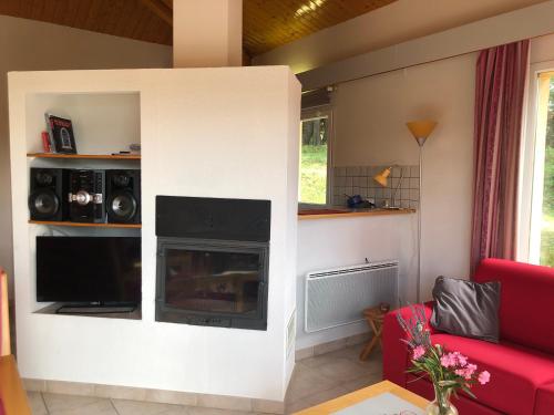 a living room with a fireplace and a red couch at l'Espinet Vacances in Quillan