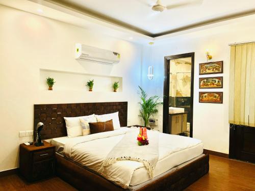 sypialnia z dużym łóżkiem z kwiatami na stole w obiekcie BedChambers Serviced Apartments South Extension w Nowym Delhi
