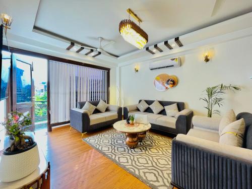 a living room with two couches and a table at BedChambers Serviced Apartments South Extension in New Delhi