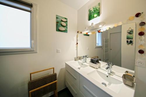 a bathroom with a sink and a mirror at L'Océraline - Maison avec jardin et wifi in La Lucerne-dʼOutremer