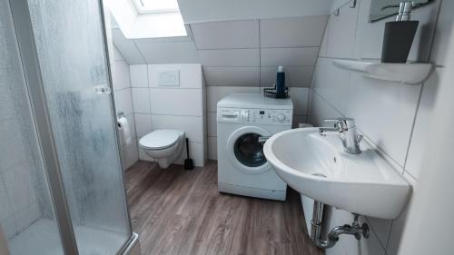 a bathroom with a washing machine and a sink at Monteurwohnungen Osnabrück Lüstringen in Osnabrück