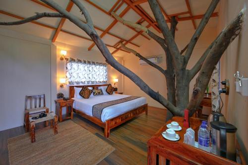 a bedroom with a tree in the middle of it at Bagh Serai - Rustic Cottage with Private Pool in Sawāi Mādhopur