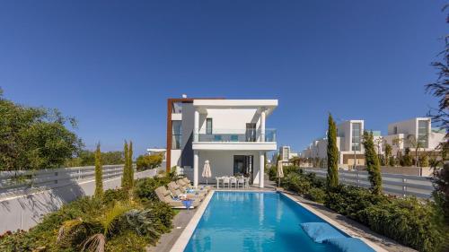 a villa with a swimming pool in front of a building at Diamond villas in Protaras