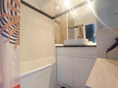 une salle de bain avec une baignoire, un lavabo et un miroir dans l'établissement Petit écrin vue Mer et Montagne, à Théoule-sur-Mer