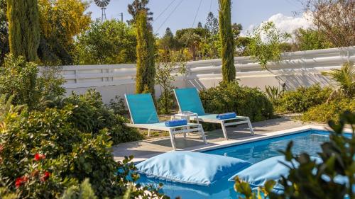 two chairs and a table next to a swimming pool at Diamond villas in Protaras