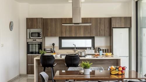a kitchen with wooden cabinets and a table and chairs at Diamond villas in Protaras