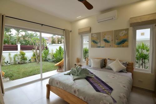 ein Schlafzimmer mit einem Bett und einem großen Fenster in der Unterkunft Villa Nokyoong in Hua Hin