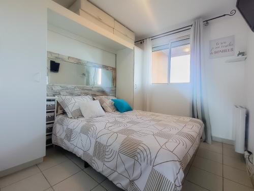 - une chambre avec un lit et un miroir dans l'établissement Petit écrin vue Mer et Montagne, à Théoule-sur-Mer