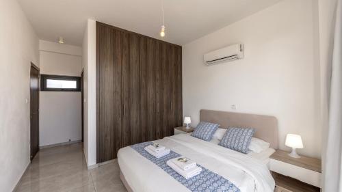 a bedroom with a large white bed with blue pillows at Diamond villas in Protaras